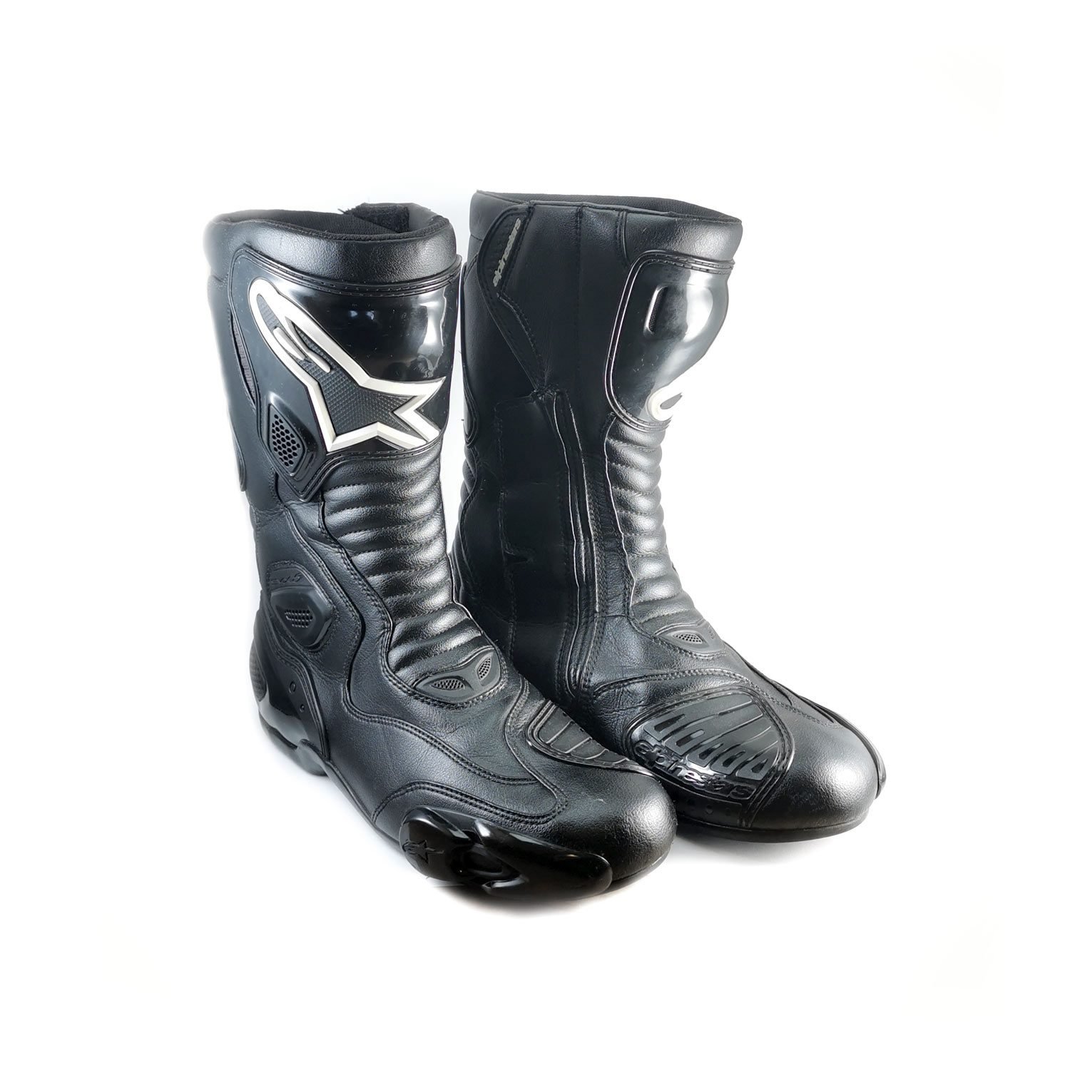 A pair of used black Alpinestars S-MX 5 SE leather racing boots in size 44. In very good condition with minor scratches, they feature comprehensive protection for the toes, heel, ankles, and shin, and are designed to be waterproof.