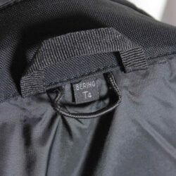 A used black Bering touring textile jacket for women in size XL. In good condition with minor wear marks, it features a detachable thermal liner, reflective elements, and pockets for optional shoulder, elbow, and back protectors.