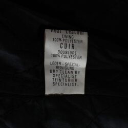 A used black Cockpit leather jacket in a vintage style, size 50/M. In fair condition, it has minor scratches and a characterful, naturally wrinkled appearance from use. It features a short connection zipper for pants and has no built-in protectors.
