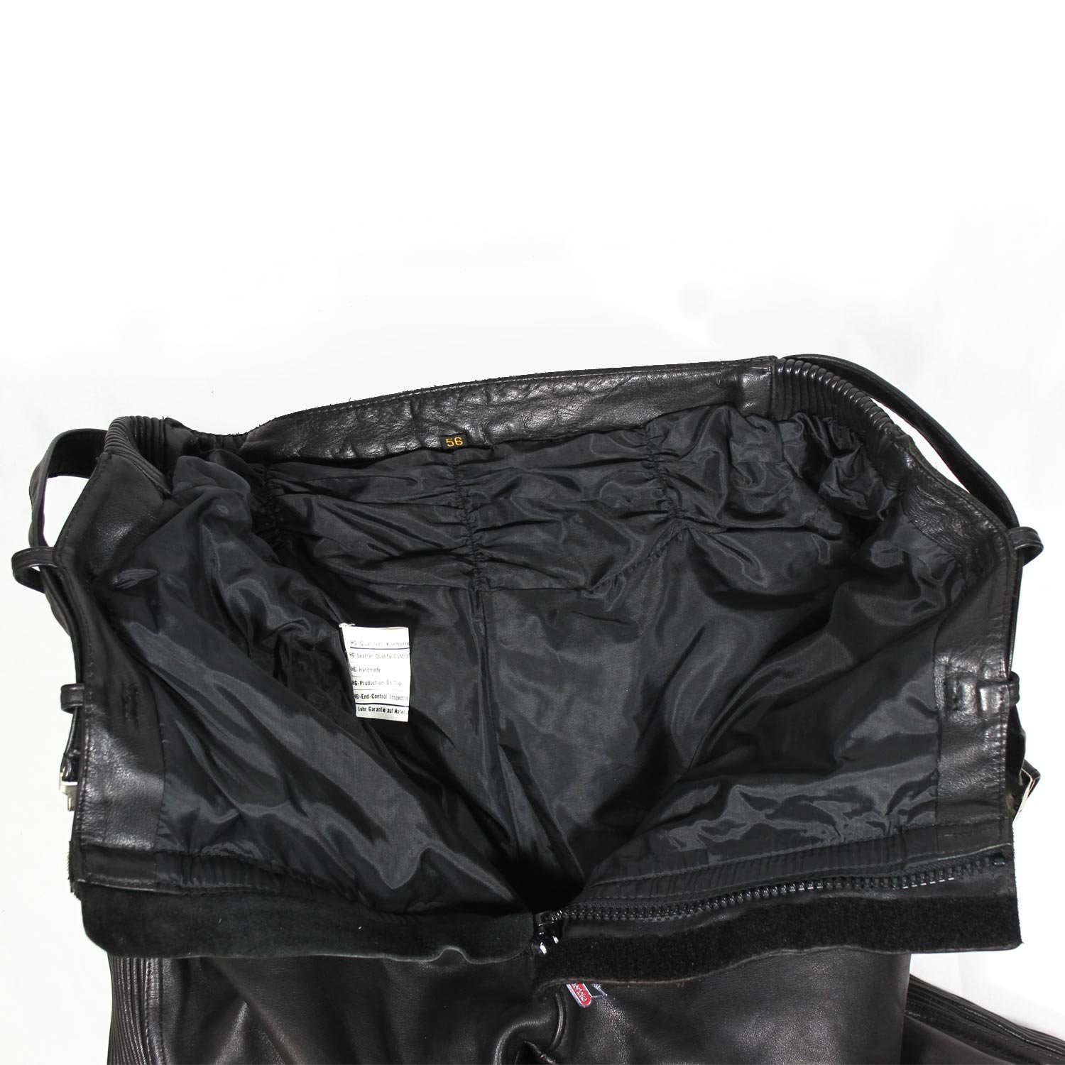 A pair of used black Hein Gericke leather pants in a vintage Café Racer style, size 56 (94 cm waist). In good condition (7.5/10) with minor use marks. Features include soft foam knee protection, an adjustable waist with a stretch panel and built-in belt, two front pockets, and a short connecting zip for a motorcycle jacket.