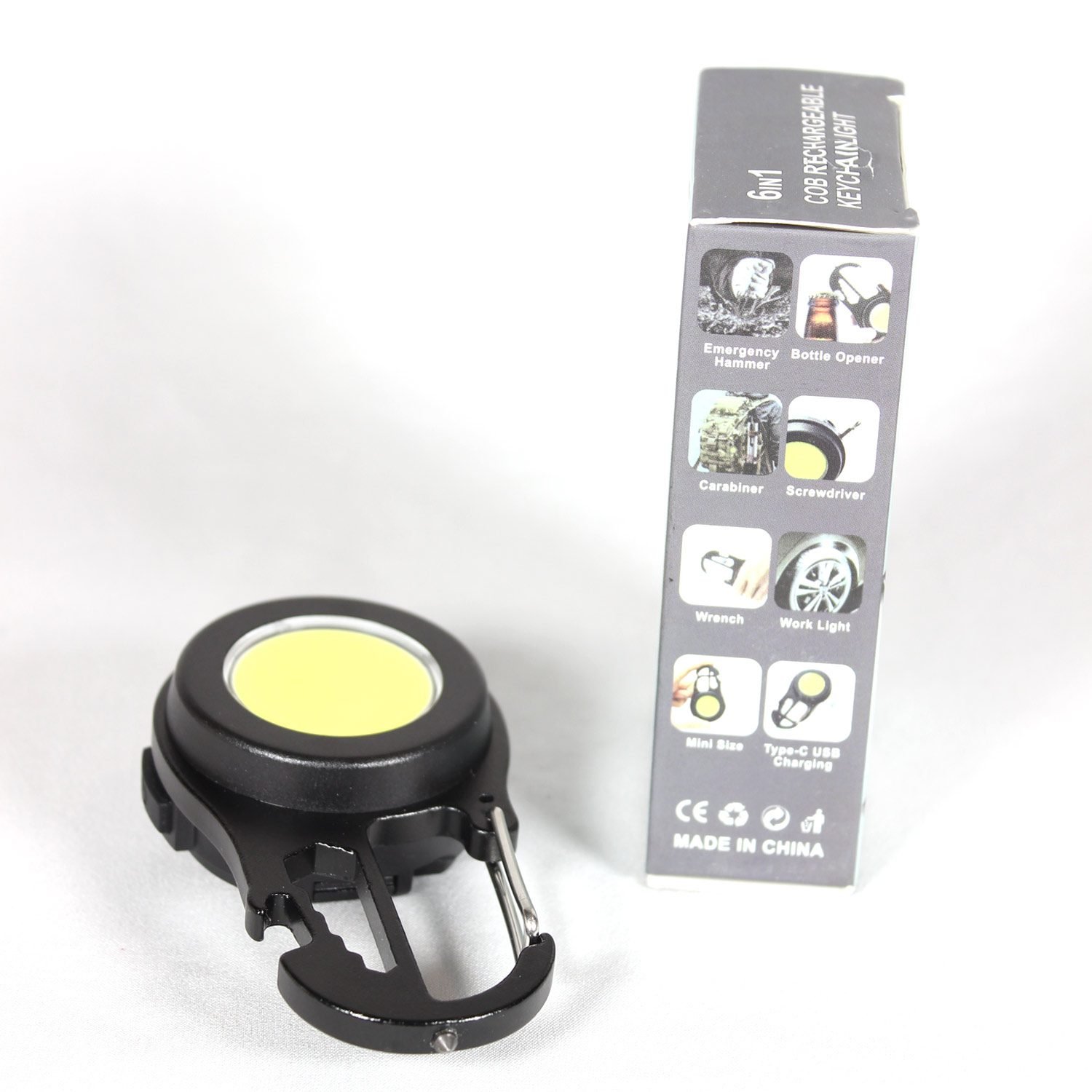 A compact black keychain flashlight with a magnetic base, shown attached to a metal surface, highlighting its USB-C port, dual LED lamps, and multifunctional lighting modes for outdoor use.