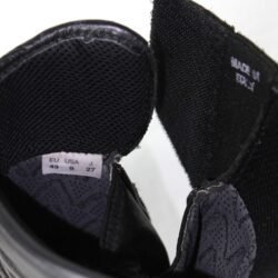 A pair of used black Gaerne G-RT racing motorcycle boots in size 43, made of leather. Features include heel, toe, gear lever, ankle, and shin protection, a non-slip oil-resistant sole, a wrap-around heel cup, and a double closure system with a zip and wide Velcro strap. Shows scratching on the plastic protectors.