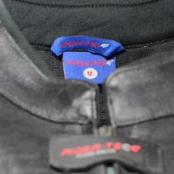 Used Rider-Tec black leather touring jacket with shoulder, elbow, and back protection, ventilation vents, and a combi-jacket connection zipper. Shows minor wear marks.