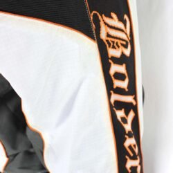 Used Bolder black and white cross pants with removable hip protectors and a Cordura waterproof membrane, showing minor wear and slight fading.