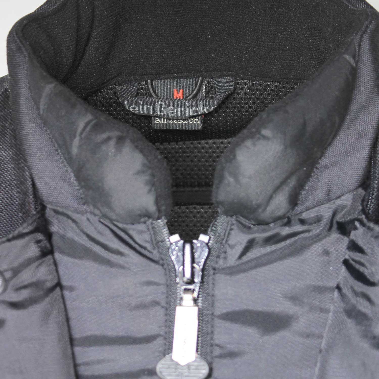 Used Hein Gericke black and red all-season touring jacket with Cordura fabric, shoulder, elbow, and back protection, a waterproof membrane, and reflective panels.