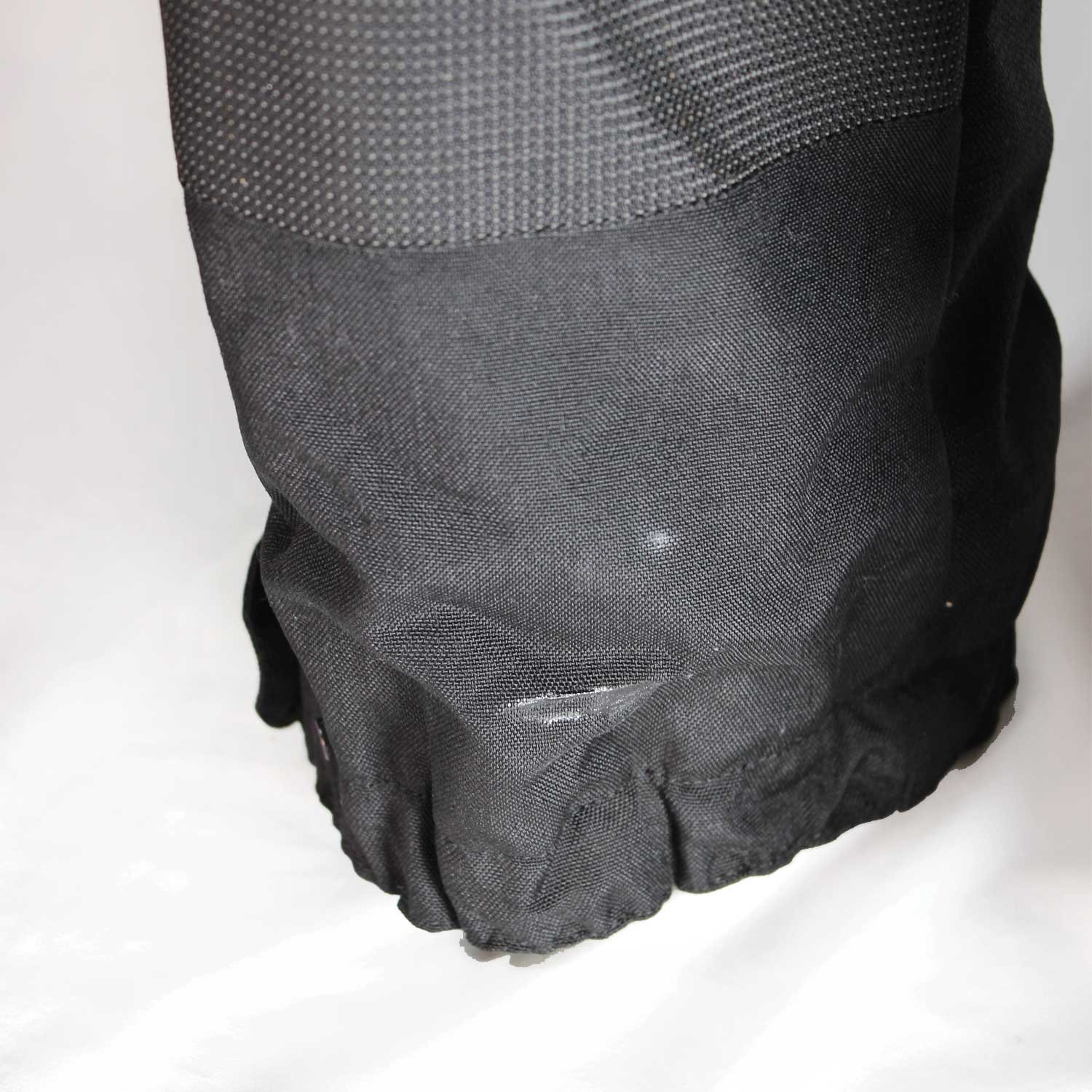 A pair of black AXO textile touring trousers in size 50. They feature a Miporex waterproof membrane and come with protectors for the knees and shins. The trousers are in fairly good condition with some wear marks and a slightly worn elastic waistband.