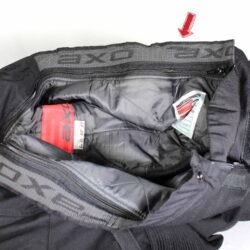 A pair of black AXO textile touring trousers in size 50. They feature a Miporex waterproof membrane and come with protectors for the knees and shins. The trousers are in fairly good condition with some wear marks and a slightly worn elastic waistband.