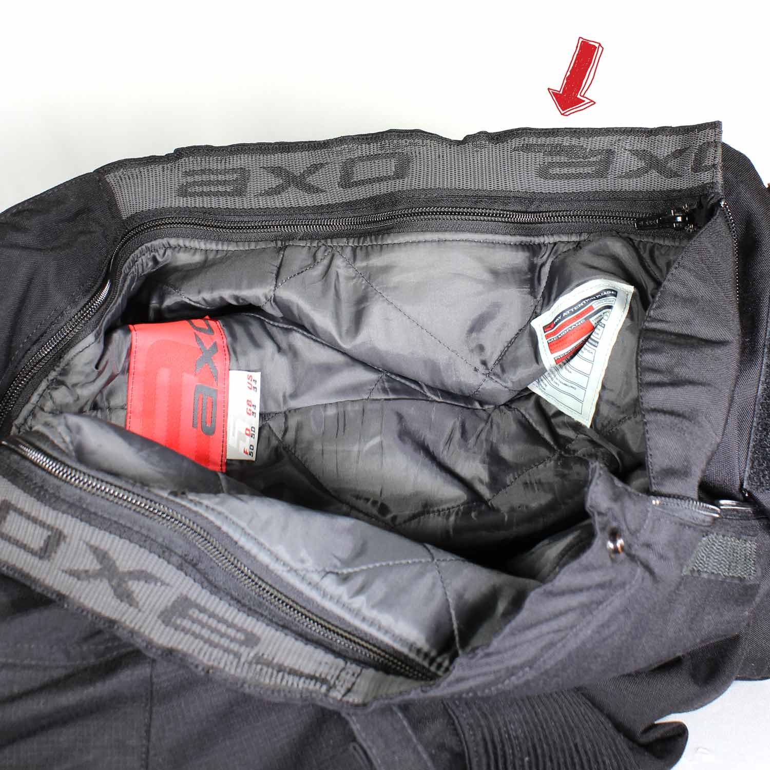 A pair of black AXO textile touring trousers in size 50. They feature a Miporex waterproof membrane and come with protectors for the knees and shins. The trousers are in fairly good condition with some wear marks and a slightly worn elastic waistband.