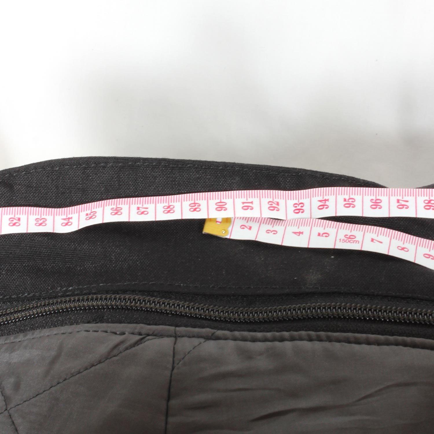 A pair of black AXO textile touring trousers in size 50. They feature a Miporex waterproof membrane and come with protectors for the knees and shins. The trousers are in fairly good condition with some wear marks and a slightly worn elastic waistband.