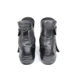 A pair of black leather touring boots, size 41, made in Germany. The boots feature a Gore-Tex membrane for waterproofing and have a high shaft. Key details include ankle protectors on both sides, a reinforced toe box, and a shin protector. The sole is a non-slip rubber with a tire tread pattern. The interior is padded with latex foam for comfort, and the insole is plastic-reinforced with a galvanized steel shank for torsion resistance. Minor wear is visible on the gear lever protection pad and the sole.