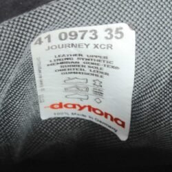 A pair of black leather touring boots, size 41, made in Germany. The boots feature a Gore-Tex membrane for waterproofing and have a high shaft. Key details include ankle protectors on both sides, a reinforced toe box, and a shin protector. The sole is a non-slip rubber with a tire tread pattern. The interior is padded with latex foam for comfort, and the insole is plastic-reinforced with a galvanized steel shank for torsion resistance. Minor wear is visible on the gear lever protection pad and the sole.