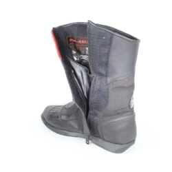 A pair of black leather MC MP-ASU Caronte touring boots in size 39. The boots feature protective reinforcements on the toes, shin, ankles, and heel, with a reinforced sole and gear/brake lever protection. They are in fairly good condition with some wear marks and are no longer waterproof.