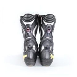 A pair of black and silver Oxtar T.C.S. racing boots in size 42, made of leather. They feature extensive protection for the shin, ankles, toes, and heel, a reinforced sole, and the patented Torsion Control System. The boots are in very good condition with minor wear; the white plastic components show some age-related yellowing.