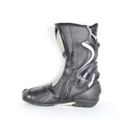A pair of black and silver Oxtar T.C.S. racing boots in size 42, made of leather. They feature extensive protection for the shin, ankles, toes, and heel, a reinforced sole, and the patented Torsion Control System. The boots are in very good condition with minor wear; the white plastic components show some age-related yellowing.