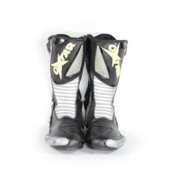 A pair of black and silver Oxtar T.C.S. racing boots in size 42, made of leather. They feature extensive protection for the shin, ankles, toes, and heel, a reinforced sole, and the patented Torsion Control System. The boots are in very good condition with minor wear; the white plastic components show some age-related yellowing.