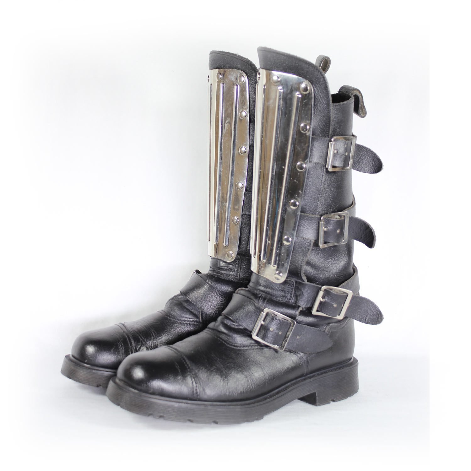 A pair of black leather Chopper-style cruiser boots by Underground Shoes in size 39. The boots feature a classic English design with metallic hardware accents and protective reinforcements on the toe, shin, and heel. They are in very good condition with minor wear marks.