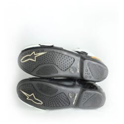 A pair of black and white Alpinestars S-MX 1.1 KTM Powerwear boots, size 44, in like-new condition. Features lightweight leather construction, accordion flex zones for walking, TPU ankle sliders, a grippy sole, and protection for the toes, heel, and shift area.