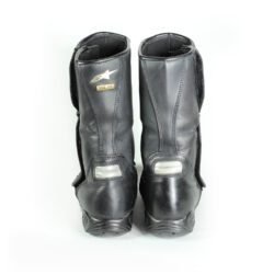 A pair of black Alpinestars high-quality leather motorcycle boots, size 38, in good condition. Made of cowhide leather with a Gore-Tex membrane, featuring reinforced protection for the toes, heel, shin, ankles, and sole. Shows typical leather wear and a minor flaw on one reflective stripe.