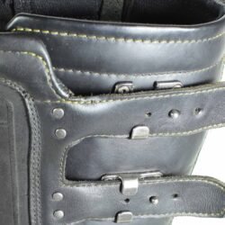 A pair of black ICON ONE THOUSAND 12" full-grain leather motorcycle boots, size 47, in good condition. Features ankle armor, reinforced shifter and shin protection, water-repellent leather, and a Goodyear welt construction. Shows typical wear, a missing screw on a back plaque, and a minor buckle flaw that does not hinder function.