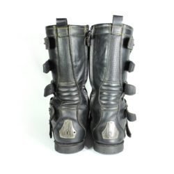 A pair of black ICON ONE THOUSAND 12" full-grain leather motorcycle boots, size 47, in good condition. Features ankle armor, reinforced shifter and shin protection, water-repellent leather, and a Goodyear welt construction. Shows typical wear, a missing screw on a back plaque, and a minor buckle flaw that does not hinder function.