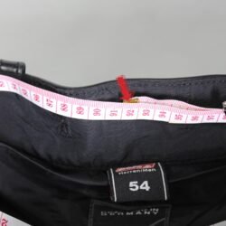 A black leather motorcycle jacket in size 54 (waist 92 cm) in very good condition. Features a café-racer style with integrated knee protection and minor wear marks. Designed for street wear.