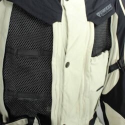 A black and beige Dainese D-Explorer adventure motorcycle jacket, size 58, in very good condition. Features an advanced modular flap system for ventilation, pockets for shoulder, elbow, and back protectors, and a removable rear exhaust vent. The jacket includes a replaceable country flag patch.