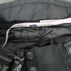 A pair of black Geneze waterproof textile motorcycle pants, size 2XL (96 cm stretch waist), in good condition. Features a Reissa-membrane, knee protectors, multiple adjustment points, reflective details, and leather reinforcements for durability.