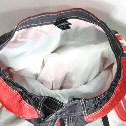 A pair of Polaris Cross motorcycle pants in black, red, and grey, size XL (96 cm stretch waist), in good condition. Features a motocross-style textile construction with integrated knee protectors.